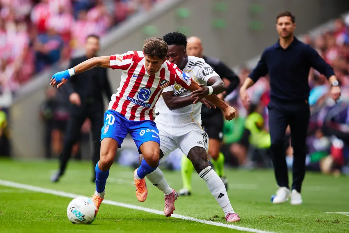 Giuliano Simeone of Atletico de Madrid competes for the ball with Vinicius Junior of Real Madrid during the LaLiga EA Sports match between Atletico de Madrid and Real Madrid CF, September 27, 2025